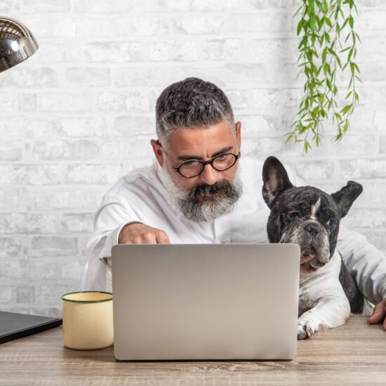 Freelance man working from home with his dog sitting together in office