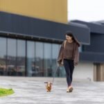 Woman walking with her dachshund dog at park